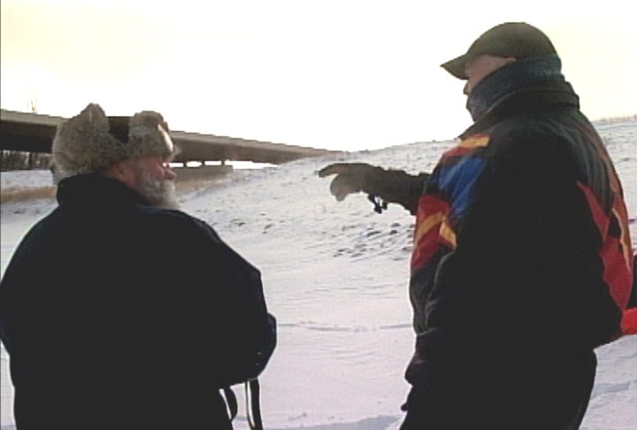 Two private investigators searching in snow.